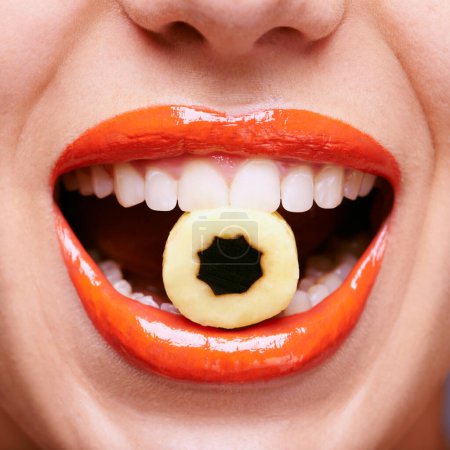 Photo for Taste the fun. a beautiful young woman eating a liquorice sweet - Royalty Free Image
