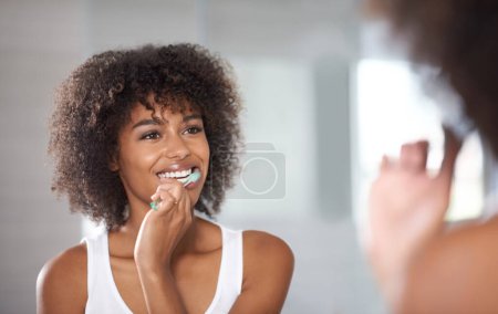Photo for Keeping a pearly white smile. a a young woman brushing her teeth - Royalty Free Image