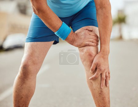 Foto de Fitness, knee pain and hands of senior man with muscle ache, painful joint and injury after running in city. Sports, body wellness and male athlete rest after workout, marathon training and exercise. - Imagen libre de derechos