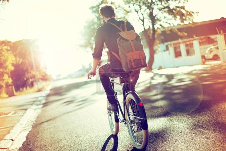 Photo for Carefree and carbon free. Rearview shot of a young man riding a bicycle outdoors - Royalty Free Image