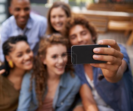 Photo for Capturing their moments of friendship. a group of friends taking a self-portrait on a cameraphone - Royalty Free Image