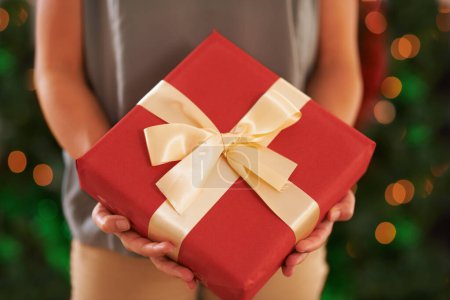 Photo pour Giving the perfect gift. a woman holding a Christmas gift - image libre de droit