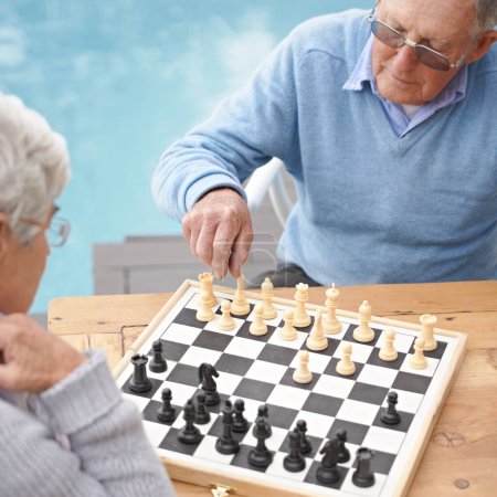 Passing the time with an engrossing game of chess. An elderly couple playing a game of chess
