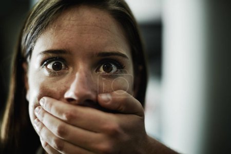 Téléchargez les photos : Silent pleas for help. A terrified young woman held captive by a man with his hand over her mouth - en image libre de droit