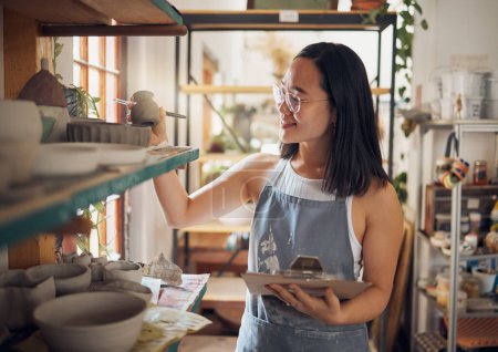 Foto de Pottery, woman or small business owner with inventory, stock and product quality, management and production results. Art startup checklist, creative worker and asian designer check design on a shelf. - Imagen libre de derechos