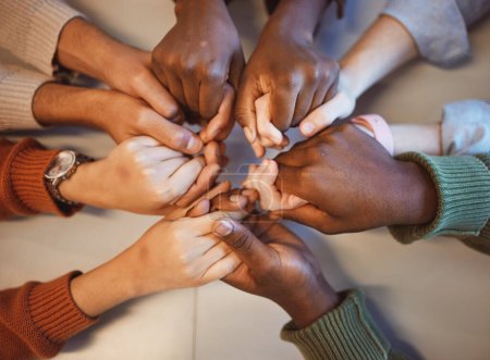 Foto de Holding hands, top view and group prayer of people with hope, support or faith, religion or spiritual praise. Community, teamwork and Christian friends, men and women praying together to worship God - Imagen libre de derechos