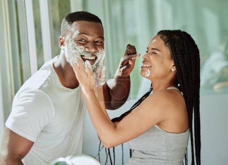 Téléchargez les photos : Shaving, playful and fun with a black couple laughing or joking together in the bathroom of their home. Love, shave and laughter with a man and woman being funny while bonding in the morning. - en image libre de droit