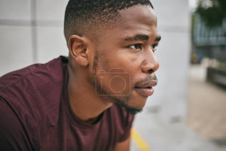 Face, fitness and exercise with a black man runner breathing alone outdoor in the city for cardio or endurance. Vision, motivation and workout with a male athlete training in an urban town for health.