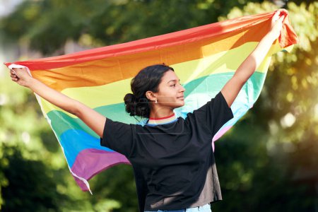 Téléchargez les photos : Rainbow, flag and human rights with an indian woman in celebration of lgbt gay pride alone outdoor. Freedom, equality and lgbtq with a happy female outside celebrating her equality or inclusion. - en image libre de droit