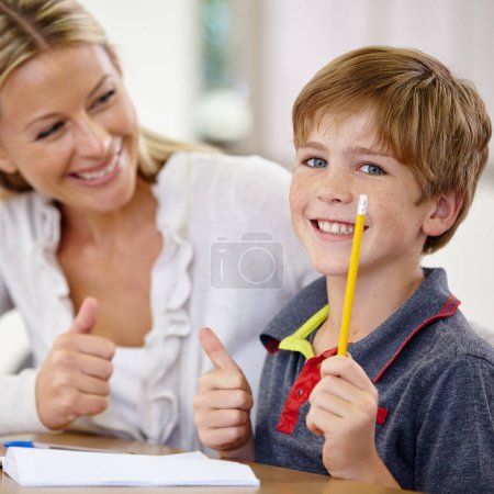 Photo for Finally got it right. A little boy looking happy after getting something right with the help of his teacher - Royalty Free Image