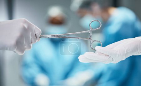 Photo pour Hospital, surgery and doctor giving scissors in hands for theatre teamwork, medical trust and support with healthcare insurance background. Metal tools, surgeon and nurse helping in an operating room. - image libre de droit