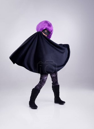 Téléchargez les photos : Costume, girl and hero outfit for fantasy, party and kid isolated on white studio background. Cosplay, female child or young person in character for play, dress up and imagination with mask and cape. - en image libre de droit