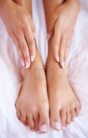 Pedicure, beauty and hands with feet on bed for salon, wellness and luxury foot wellbeing at home. Skincare aesthetic, cosmetics and toes with nail polish for pampering, spa and beauty treatment.