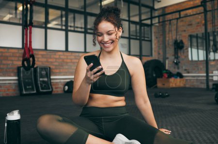 Téléchargez les photos : Happy woman, fitness and phone at gym for a workout, training and body wellness with a mobile app. Sports female with smartphone for progress, performance and communication for a healthy lifestyle. - en image libre de droit