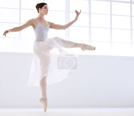 Photo for Control and perfection. Graceful young ballerina in white dancing en pointe - Royalty Free Image