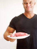Making sure he gets enough protein in his diet. Portrait of a bodybuilder holding out a plate of raw beef Mouse Pad 634816628