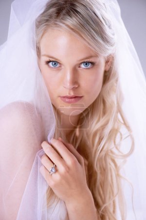 Foto de Veiled beauty. Closeup portrait of a beautiful young bride wearing a veil and wedding ring - Imagen libre de derechos