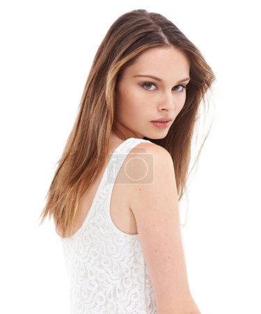 Beautiful young woman, brown hair and beauty face standing with sensual look against a white studio background. Portrait of isolated attractive female looking over shoulder on a white background.