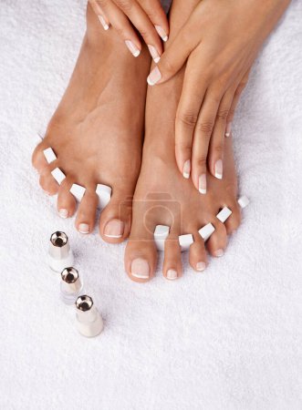 Feet, hands and beauty pedicure of woman for aesthetic, wellness and grooming. Skincare cosmetics, manicure treatment and female model with foot, toe spacers and nail polish for painting nails at spa.
