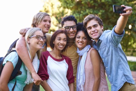 Photo for Taking pictures of wonderful memories. A happy group of college students smiling for a picture about to be taken - Royalty Free Image