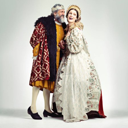 Téléchargez les photos : King, queen and love in medieval costume for royal party, retro carnival and theatre fashion clothes in white background. Couple, happy face and talking in vintage renaissance isolated in studio. - en image libre de droit