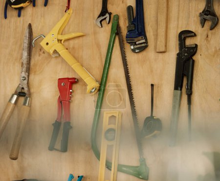 Photo for An arrangement of tools on a wooden wall. Closeup of a collection of tools hanging. Neat, tidy mechanics tools and equipment on a wall. Still life of tools in storage. Various tools in a workshop. - Royalty Free Image