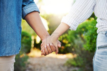 Foto de Hand in hand. an affectionate unrecognizable couple walking hand in hand in their yard at home - Imagen libre de derechos
