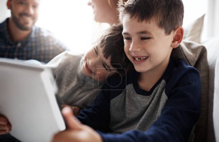 Téléchargez les photos : Laughing kids, bonding or tablet for movies streaming, esports or social media on house or family home living room. Smile, happy or fun brother on digital technology, children learning or team gaming. - en image libre de droit