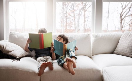 Téléchargez les photos : Kids, bonding reading books in education, learning or relax studying on house living room or family home sofa. Happy children, storytelling or fantasy fairytale novel in hobby or creative inspiration. - en image libre de droit