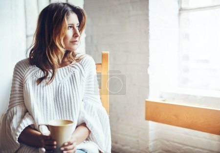 Relax, thinking and woman drinking coffee in her home, content and quiet while daydreaming on wall background. Tea, comfort and calm female enjoying peaceful morning indoors while looking out window.