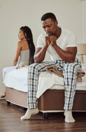 Foto de Marriage, fight and sad couple in a bedroom angry from conflict and divorce talk on a bed. Black people, depression and woman with man feeling anxiety and stress problem from breakup in a home. - Imagen libre de derechos