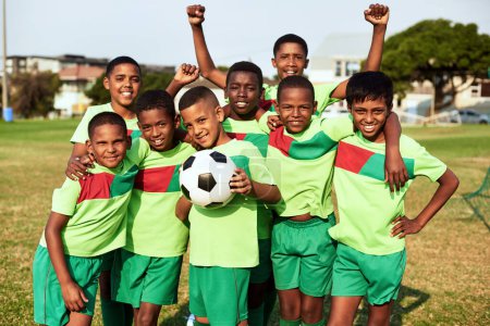 Téléchargez les photos : Future football pros in the making. Portrait of a boys soccer team standing together on a sports field - en image libre de droit