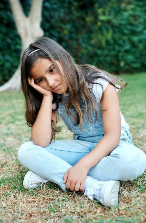 Photo for I have no one to play with today. a young looking sad while sitting outside - Royalty Free Image