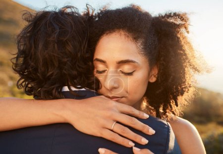 Foto de Wedding, black woman and man hug at sunset together for care, love and support for married life. Romantic, commitment and marriage event of young people in Cape Town, South Africa nature - Imagen libre de derechos