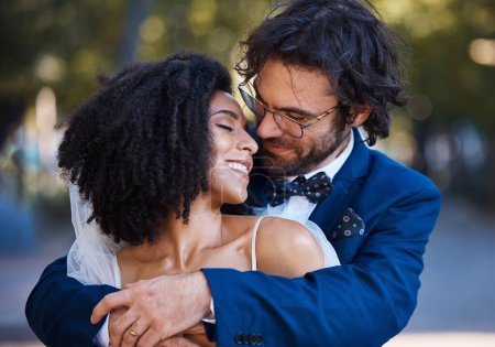 Téléchargez les photos : Wedding, couple hug and marriage outdoor with commitment, trust and love with bride and groom in park. Happiness, life partner with married man and black woman, interracial relationship and smile. - en image libre de droit
