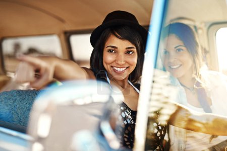 Photo for Friendship is all about making discoveries along the way. a happy young woman pointing at something on a road trip with her friend - Royalty Free Image