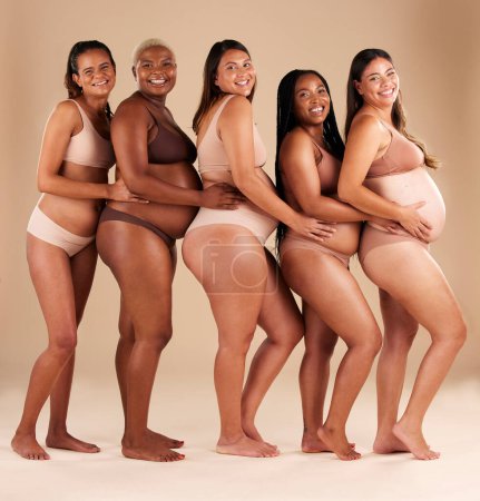 Foto de Portrait, pregnant and happy women in row on studio background in community, diversity or baby support group. Smile, happy or bonding mothers with pregnancy stomach, underwear or healthcare wellness. - Imagen libre de derechos