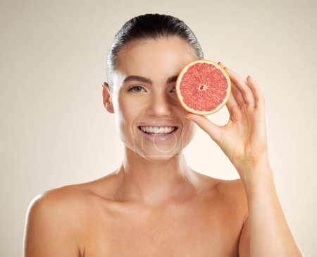 Téléchargez les photos : Skincare, beauty and woman portrait with grapefruit for natural skin dermatology or cosmetics. Vitamin c fruit on happy face aesthetic model in studio for sustainable health and wellness self care. - en image libre de droit
