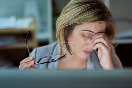 Photo for Shes been looking at that screen for far too long. a businesswoman looking stressed while working late in the office - Royalty Free Image