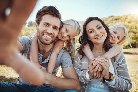 Foto de Selfie, park and portrait of children with parents enjoying quality time in nature, weekend and holiday. Family, love and happy girls, mom and dad smile for photo bonding, relax and fun together. - Imagen libre de derechos
