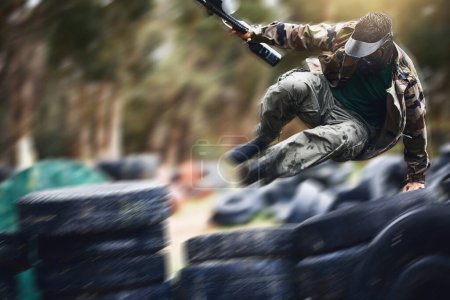 Téléchargez les photos : Fast, moving and man playing paintball with action, military clothes and running during a game in Australia. War, sport and person with blurred motion during a fun, playful and outdoor competition. - en image libre de droit