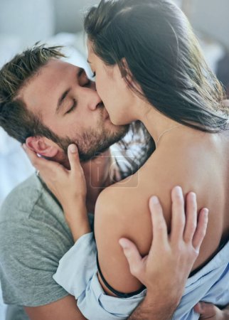 Foto de Me encanta la forma en que me besas. una joven pareja compartiendo un momento íntimo en su dormitorio - Imagen libre de derechos