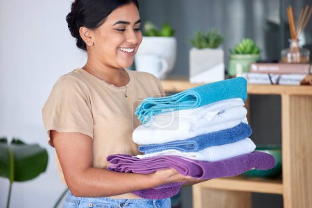 Téléchargez les photos : Laundry, housework and towels with a woman cleaner working in a home for domestic hygiene as a maid. Cleaning, hospitality and fabric with a female housekeeper at work in a hotel room or house. - en image libre de droit