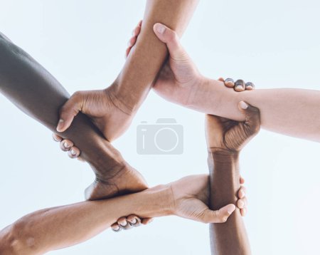 Foto de Below, hands and team, sports and collaboration, partnership and huddle against sky background. Bottom, fitness and friends hand in support of teamwork, goal and mission, diversity and training. - Imagen libre de derechos