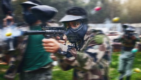 Foto de Paintball gun, shooting and men in camouflage with safety gear at military game for target practice. Teamwork, sports training and war games, play with rifle and friends working together at army park. - Imagen libre de derechos