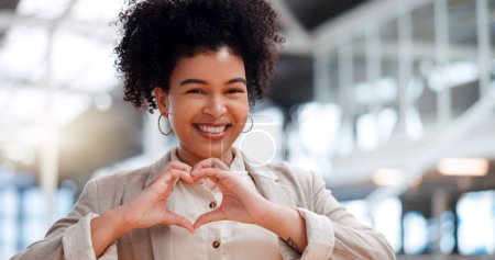 Black woman with hand heart, face and career love, happy with corporate business and professional success. Modern office, happiness and vision, sign with hands and pride in job, portrait in workplace.
