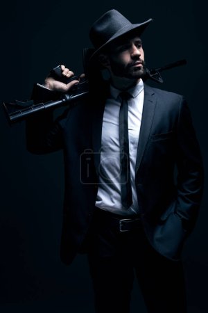 Téléchargez les photos : Hitman, suit or holding gun on studio background in dark secret spy, isolated mafia leadership or crime lord security. Model, man or gangster weapon in formal, fashion clothes or bodyguard aesthetic. - en image libre de droit