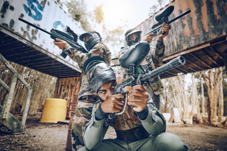 Téléchargez les photos : Paintball teamwork, shooting together and war game with vision, mask or tactical strategy for safety in competition. Military training, team building and group with weapon, combat and friends outdoor. - en image libre de droit