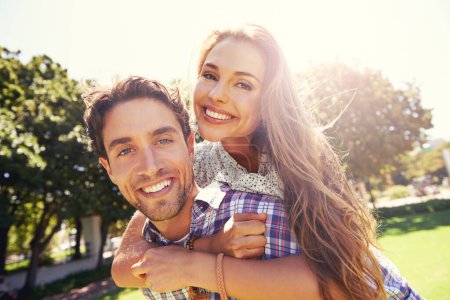 Couple portrait, smile and piggyback on love, valentines day or romance date in park bonding, garden backyard or nature. Happy, man and carrying woman in fun game, freedom security or energy support.