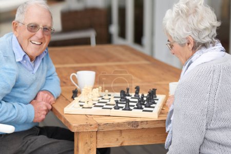 Téléchargez les photos : Every king needs a queen. An elderly couple playing chess together - en image libre de droit